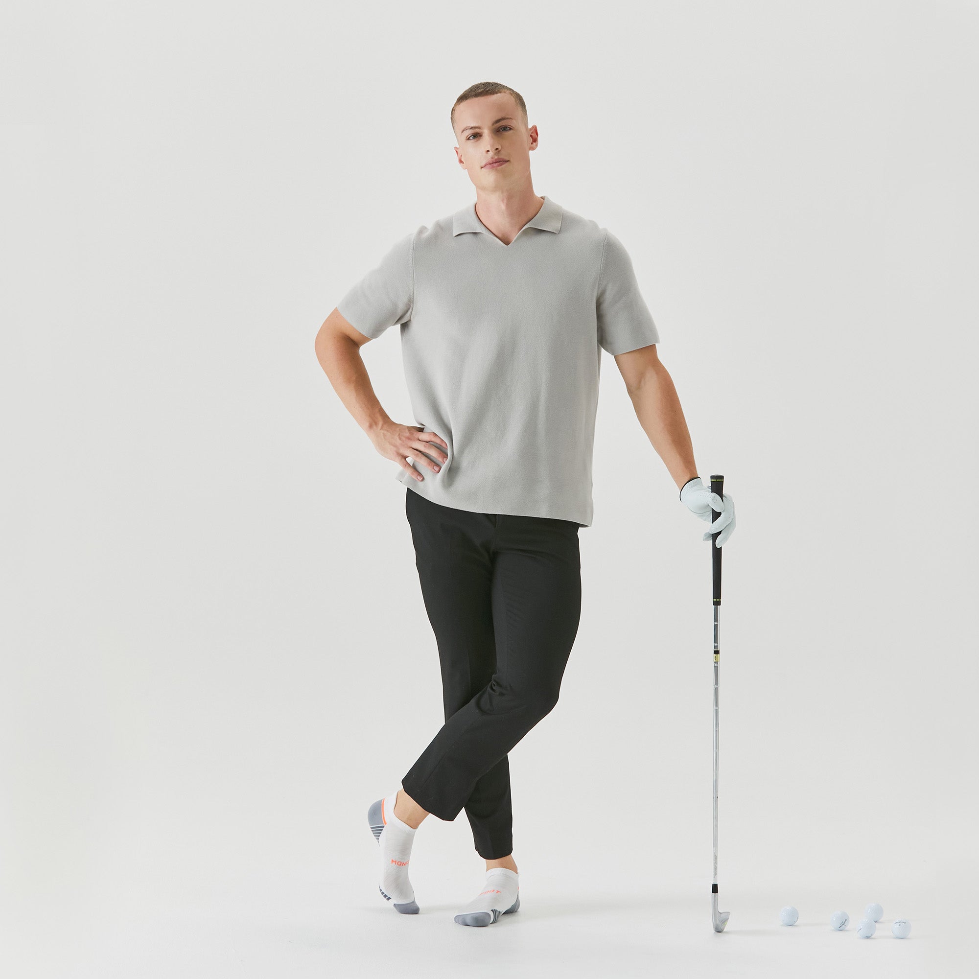 A man in a gray shirt is holding a stick.