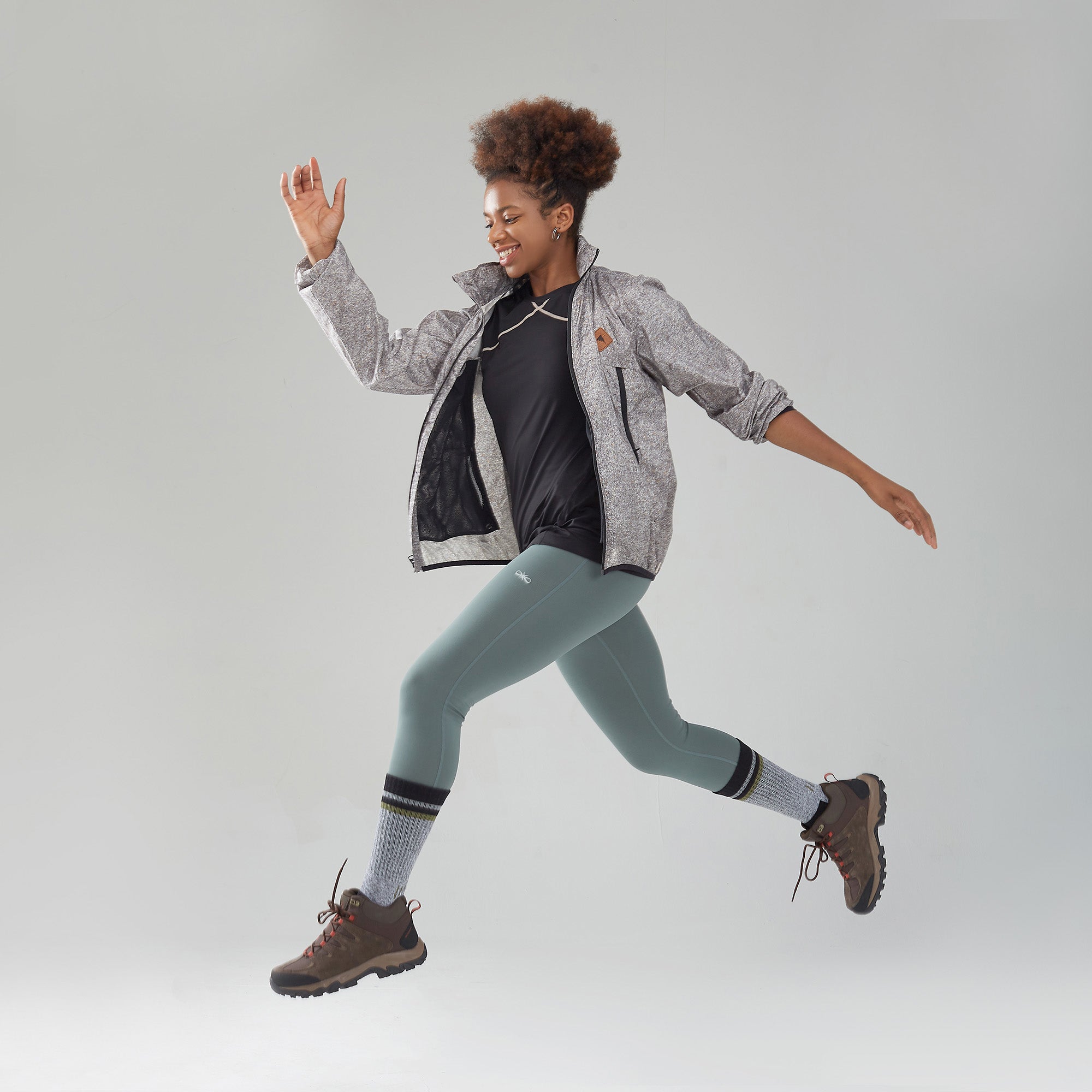 A woman is jumping in the air with her hands in the air.