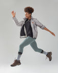 A woman is jumping in the air with her hands in the air.