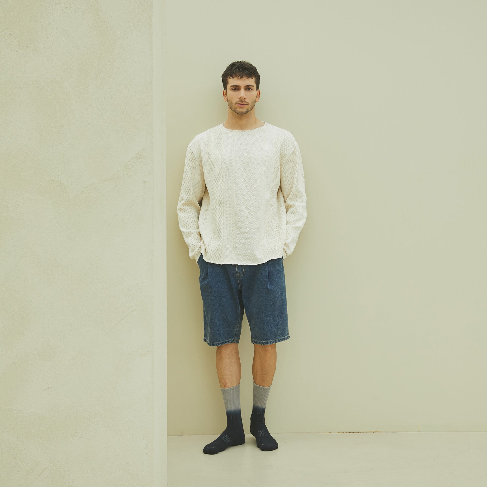 A man standing in front of a white wall.