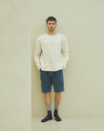 A man standing in front of a white wall.