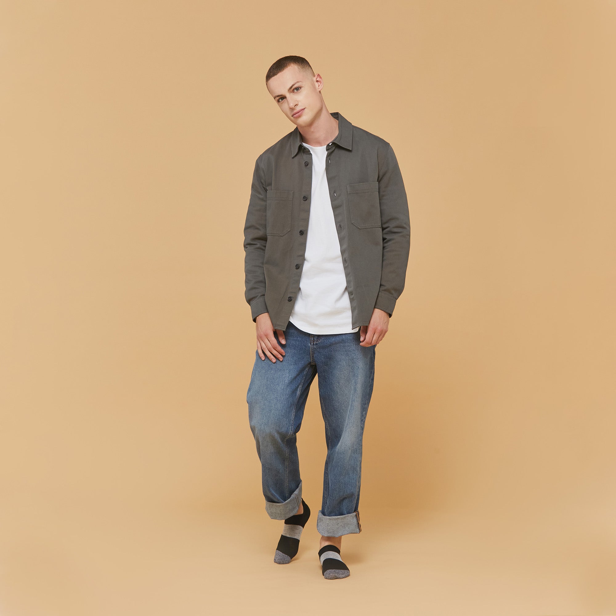 A man standing in front of a brown background.