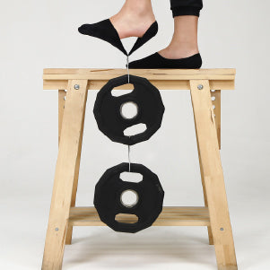 A woman standing on top of a wooden stool.