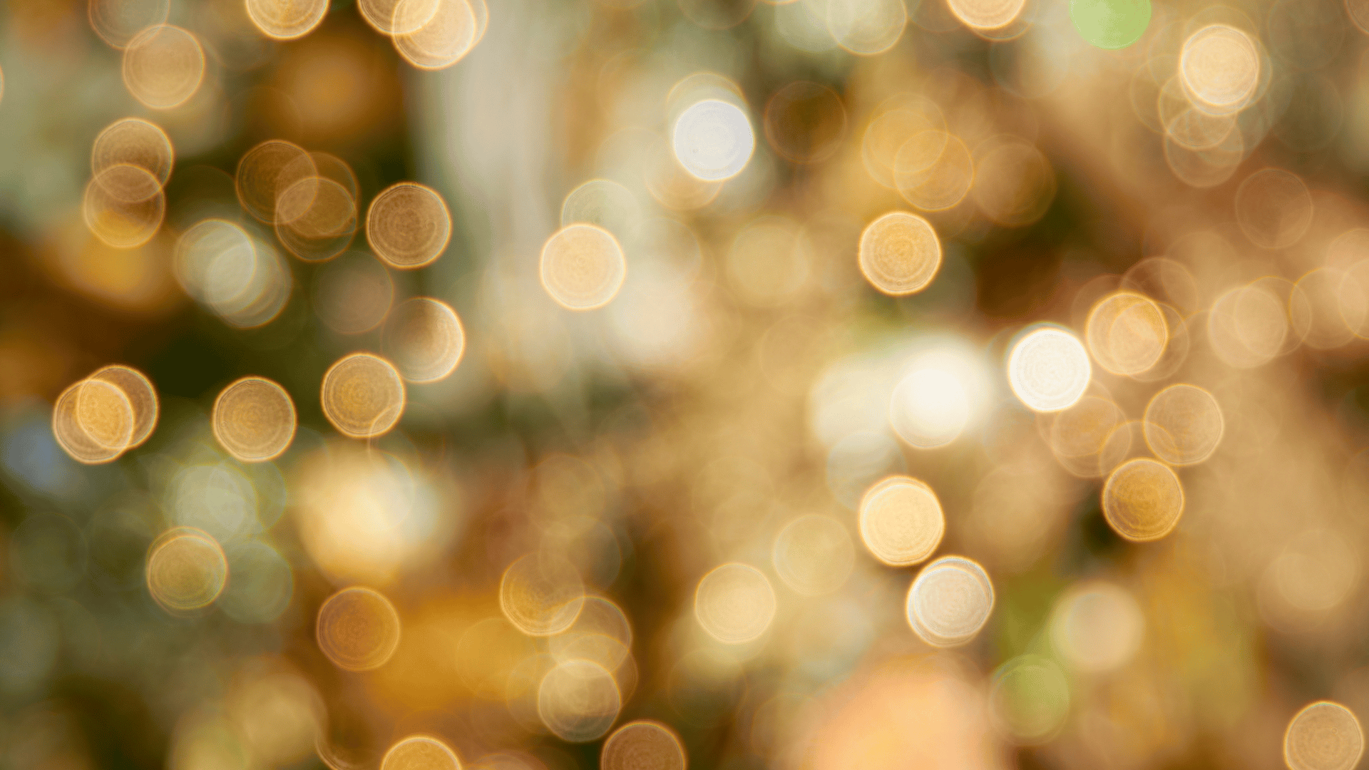 Blurred holiday lights in warm gold and yellow tones creating a bokeh effect.